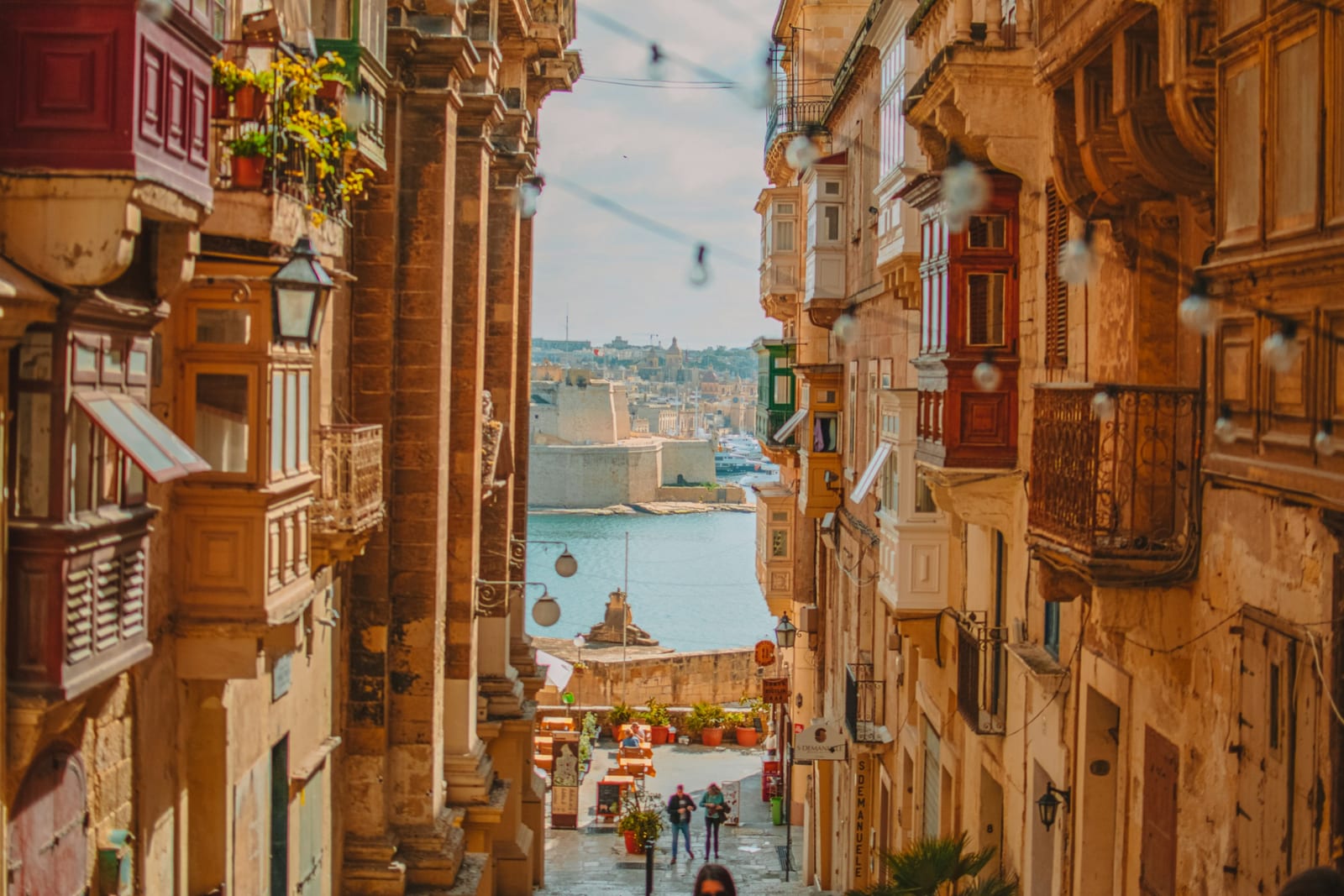 나무 발코니가 이어진 발레타 골목과 그 끝의 항구